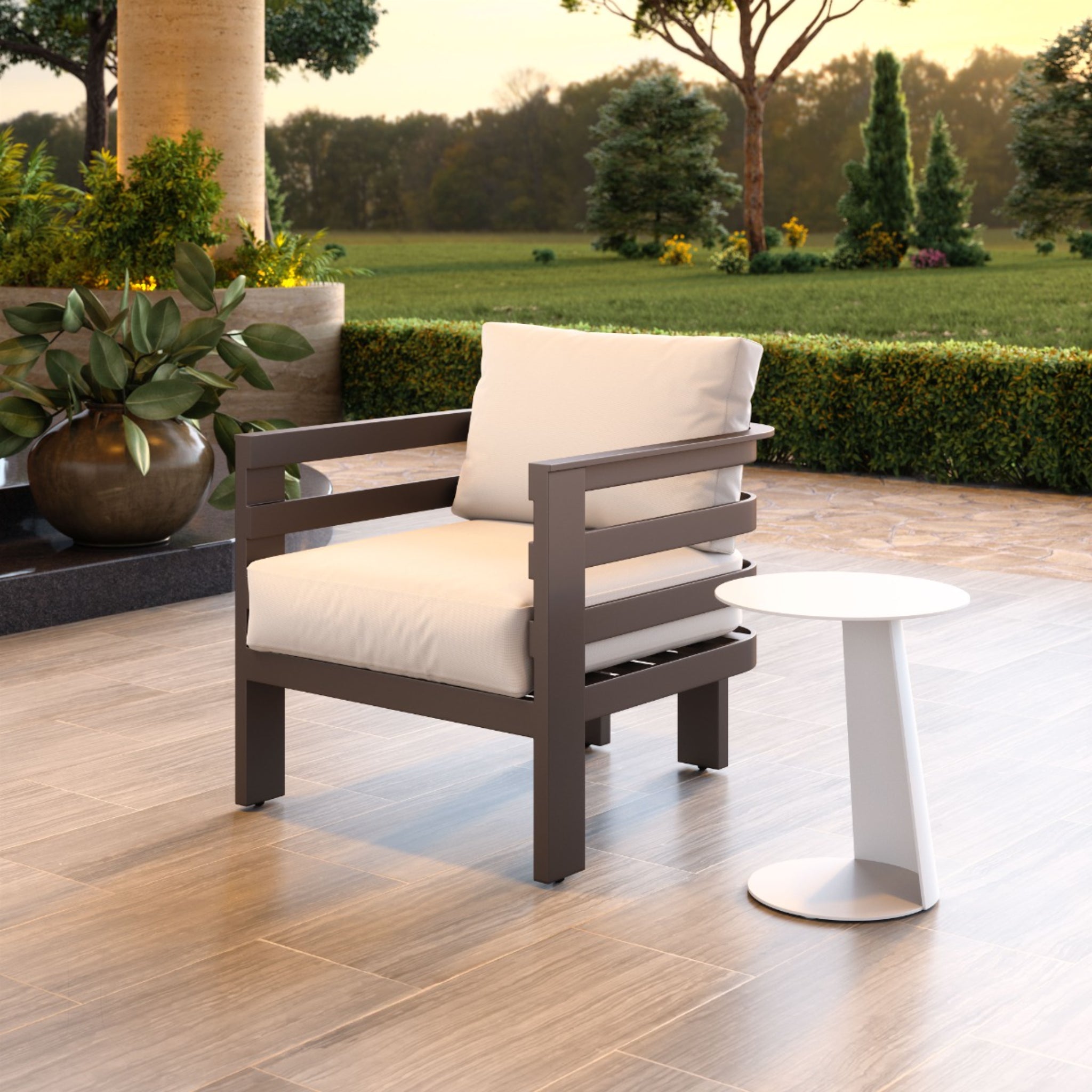 Modern-armchair-with-white-cushions-next-to-round-side-table-in-garden-setting---productpage---