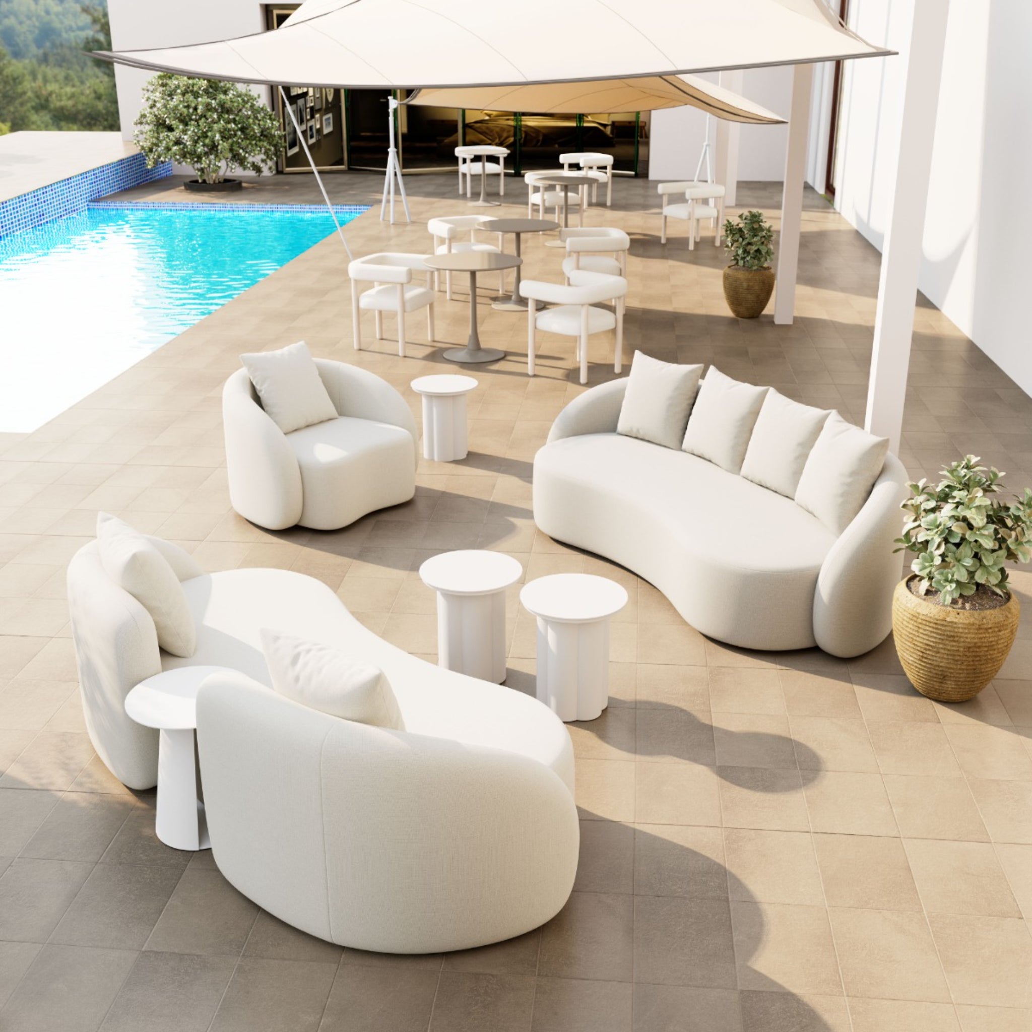 Stylish patio seating arrangement with plush cream sofas, white side tables, and a shaded area next to a swimming pool.