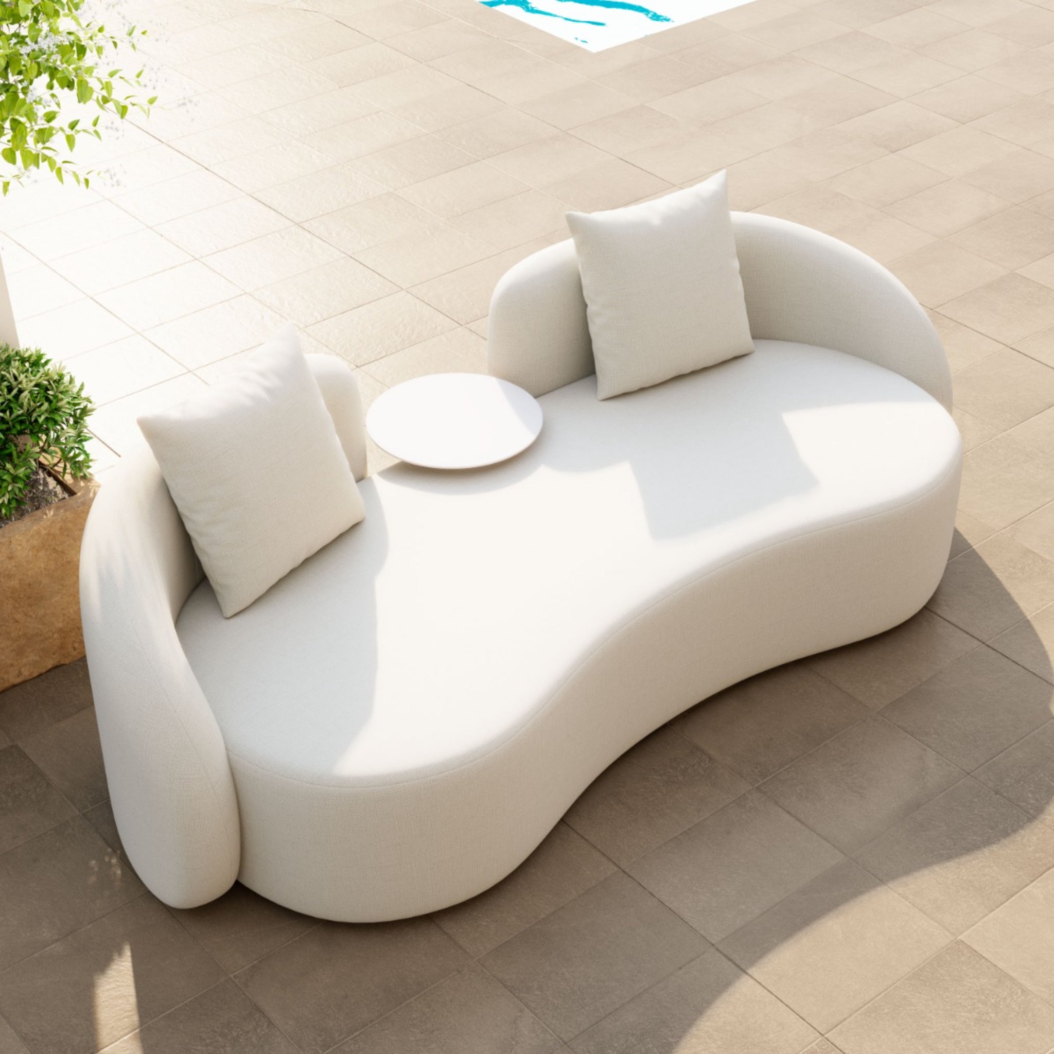 Light-beige-outdoor-sofa-with-curved-design-and-two-pillows---poolside-setting---productpage---